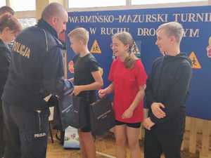 Policjant wręcza nagrody zwycięskiej drużynie z grupy starszej z SP nr 3 w Działdowie
