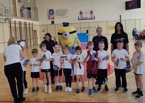 jedna z drużyn biorących udział w konkursie na zdjęciu grupowym z maskotką Minionkiem, opiekunem i policjantkami