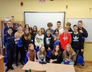 ósmoklasiści z policjantką i policjantem w klasie - zdjęcie grupowe
