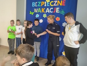 Policjantka wręcza uczennicy kartę rowerową